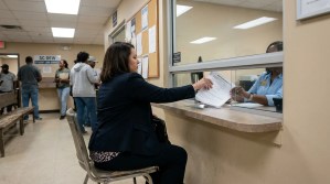 woman submitting wage garnishment notice documents at SC DEW government office window